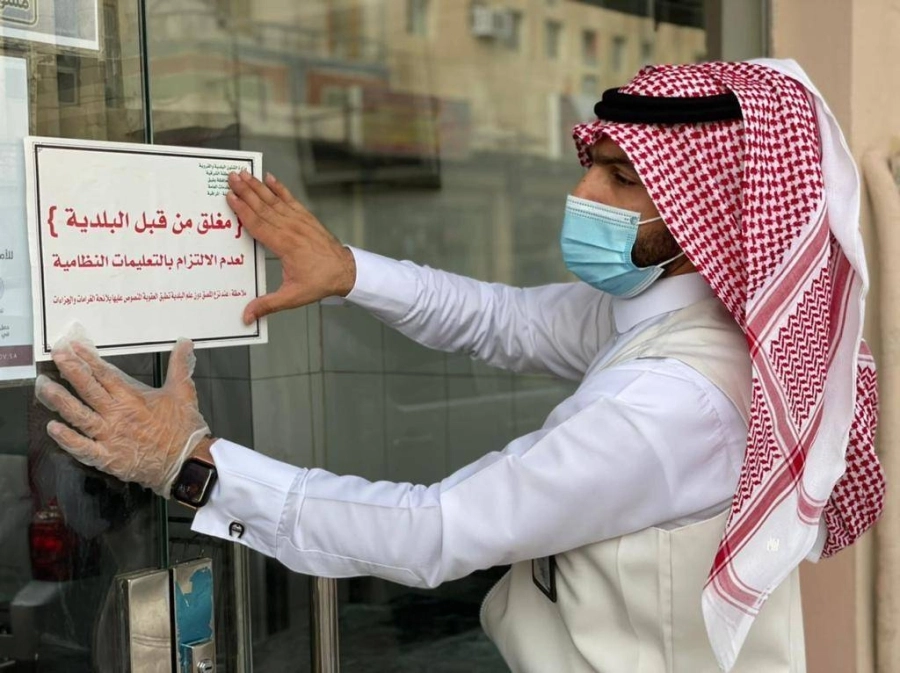 



مراقب البلدية خلال إغلاق أحد المحال    (مكة)