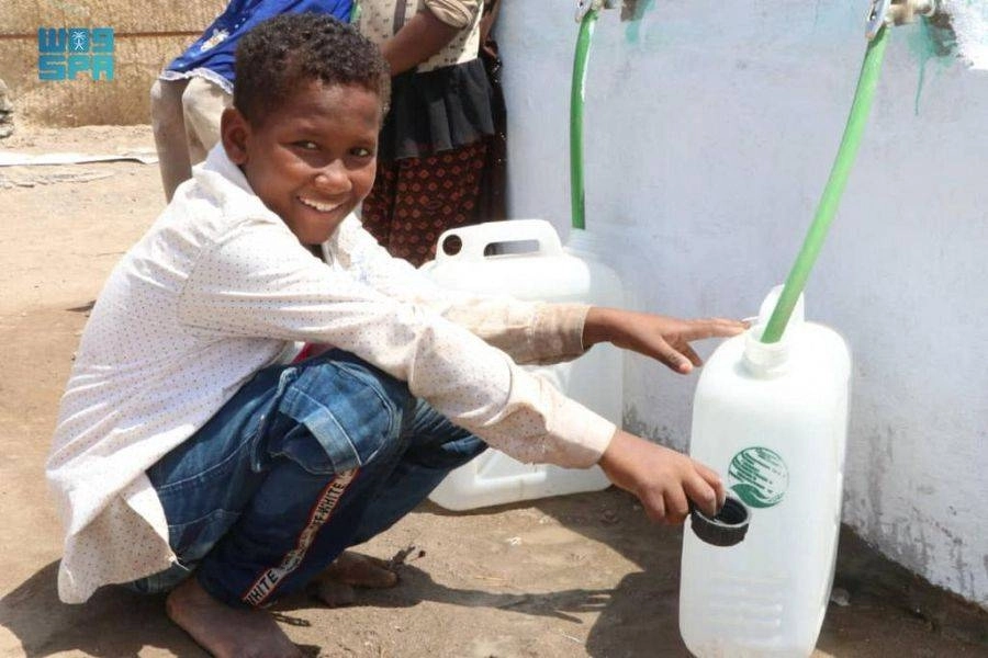 طفل يمني يبتسم وهو يحصل على حاجته من المياه (واس)