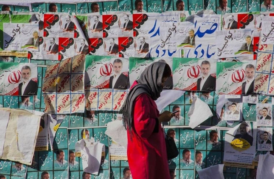 ايرانية تمر من أمام ملصقات دعائية للانتخابات (مكة)