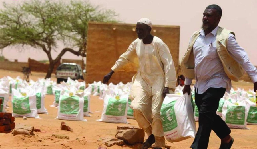 سودانيان يحملان مساعدات مركز الملك سلمان للاغاثة (واس)