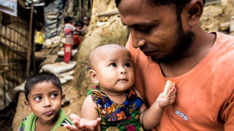 أب لاجئ يحتضن طفليه (مكة)