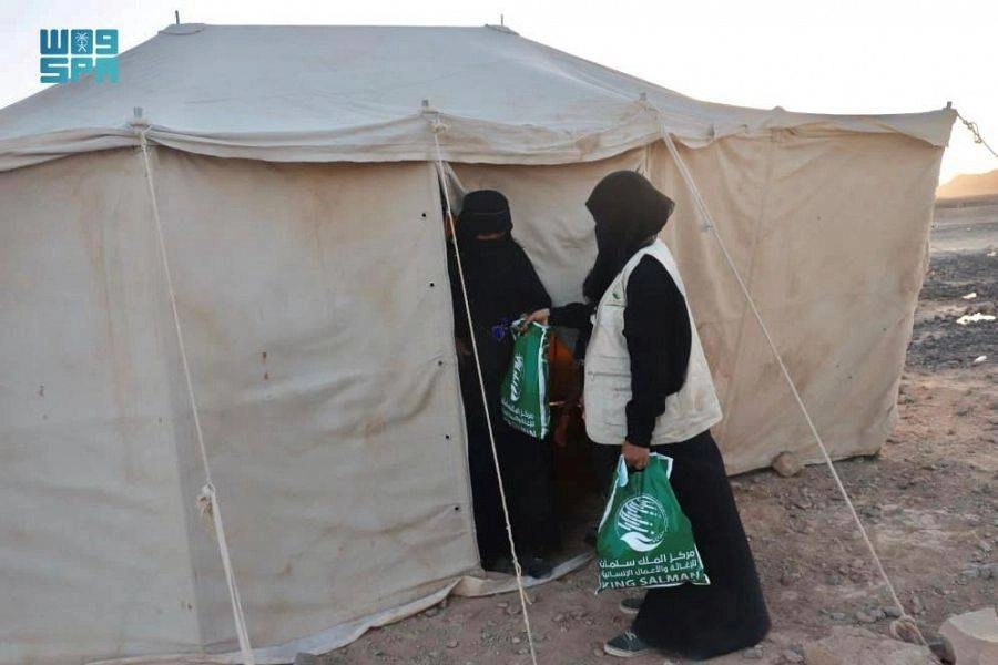 يمنية تتسلم ملابس من متطوعة بالمركز        (واس)