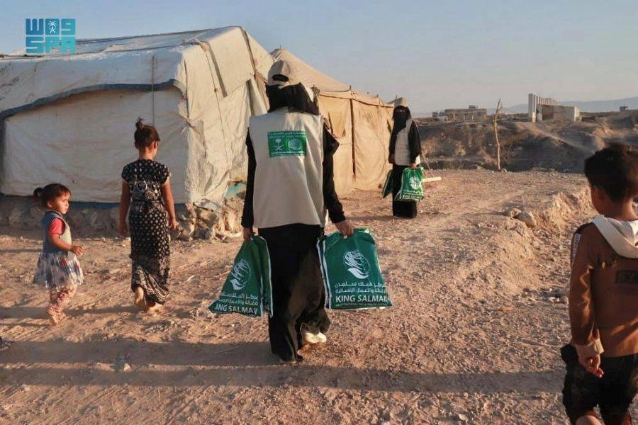 أسرة يمنية تنتظر ملابس مركز الملك سلمان للإغاثة     (واس)