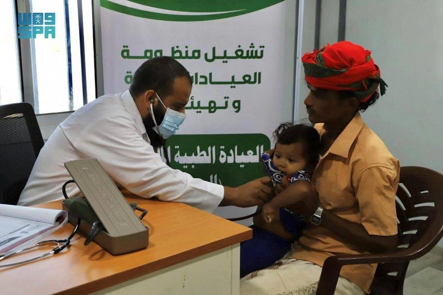 طبيب يكشف على طفلة يمنية في العيادات المتنقلة      (واس)