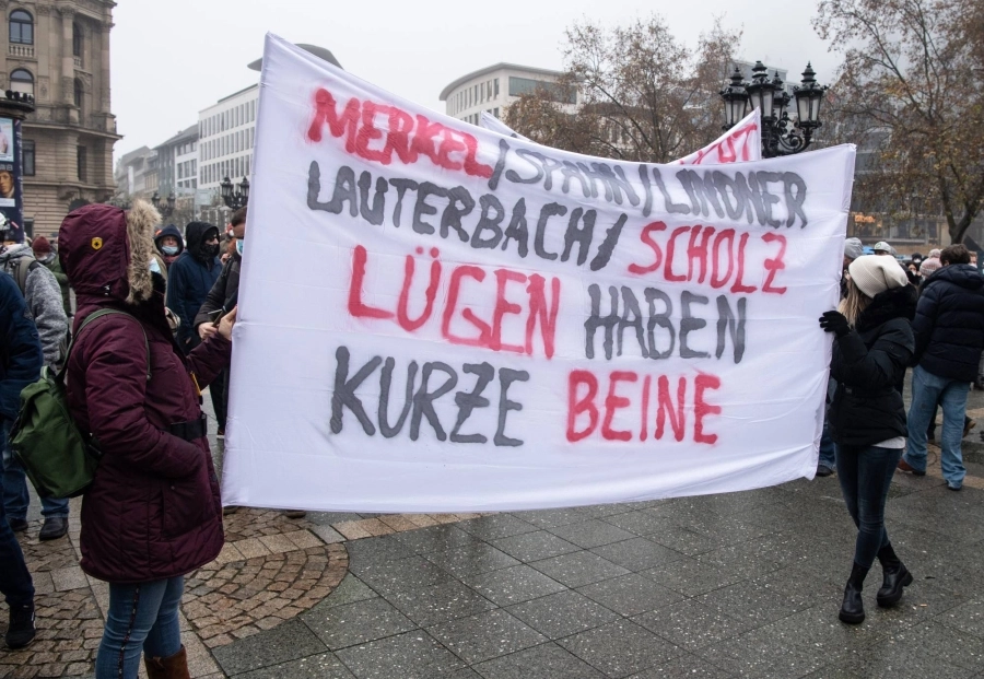 






محتجون يحملون لافتة ضد ميركل