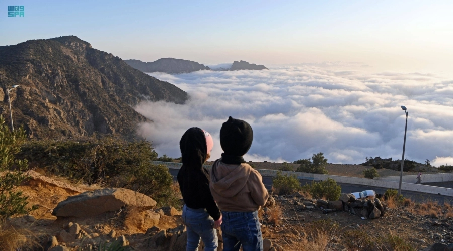 طفلان يستمتعان بمنظر السحب المنخفضة                 (مكة)
