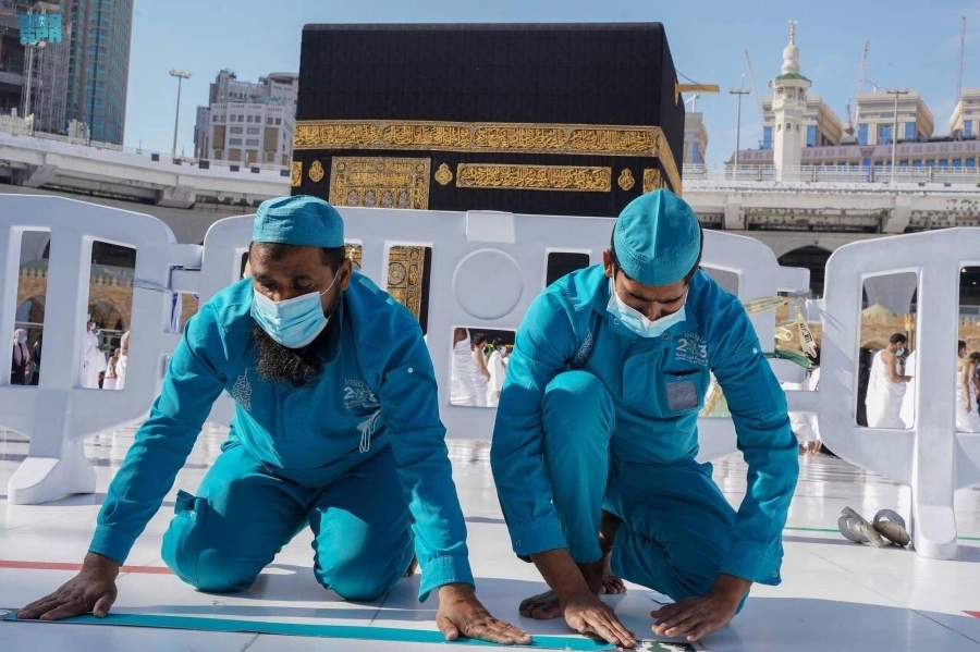 






عاملان خلال إعادة الملصقات                      (مكة)