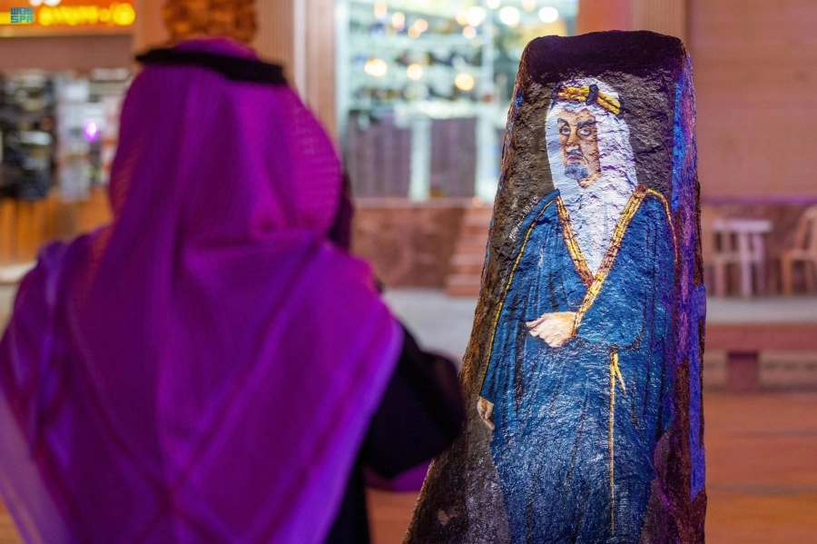 زائر يقف أمام رسم لشخصية الملك فيصل        (مكة)