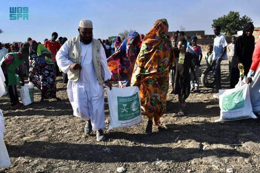 المستفيديون يحملون السلال عقب توزيعها