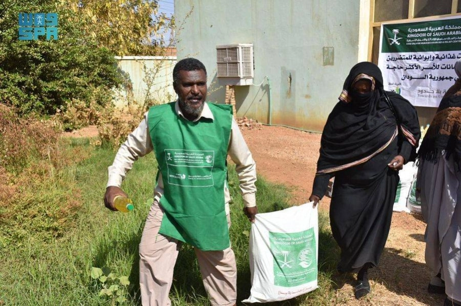 متطوع يساعد سودانية       (واس)