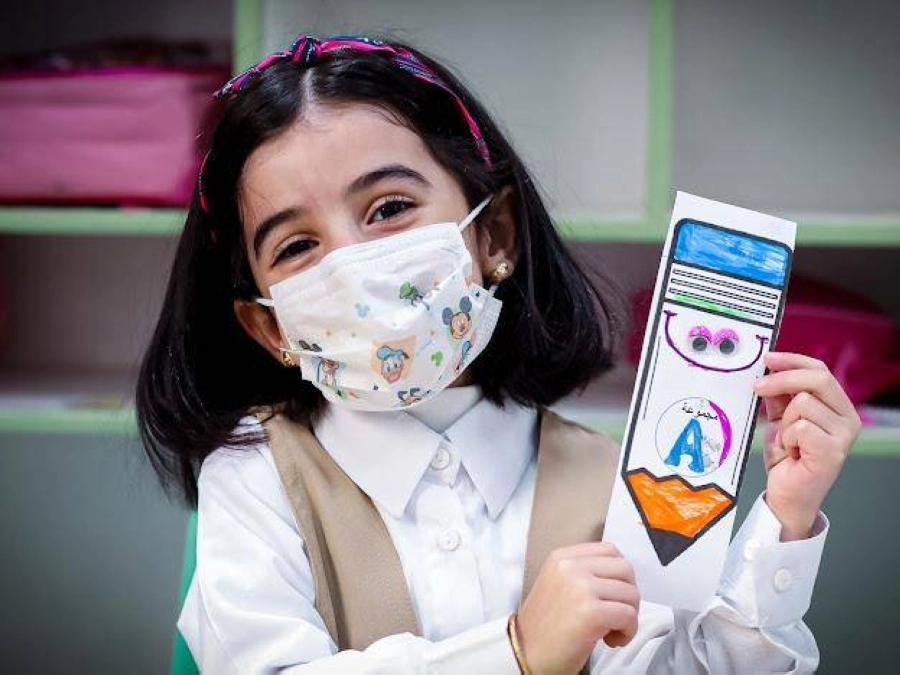 طالبة فرحة بالعودة الحضورية