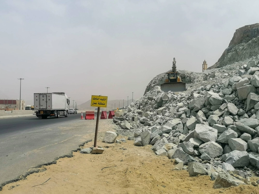 معدات أحد مشاريع الخط الدائري الرابع في العاصمة المقدسة تعمل في تكسير الصخور وتفتيتها، معرضة السيارات المارة للخطر بسبب ضعف المصدات الموضوعة على حافة المشروع.
