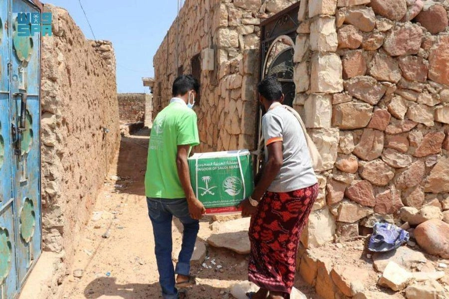 يمنيان يحملان سلة لأحد المنازل في سقطرى                             (واس)