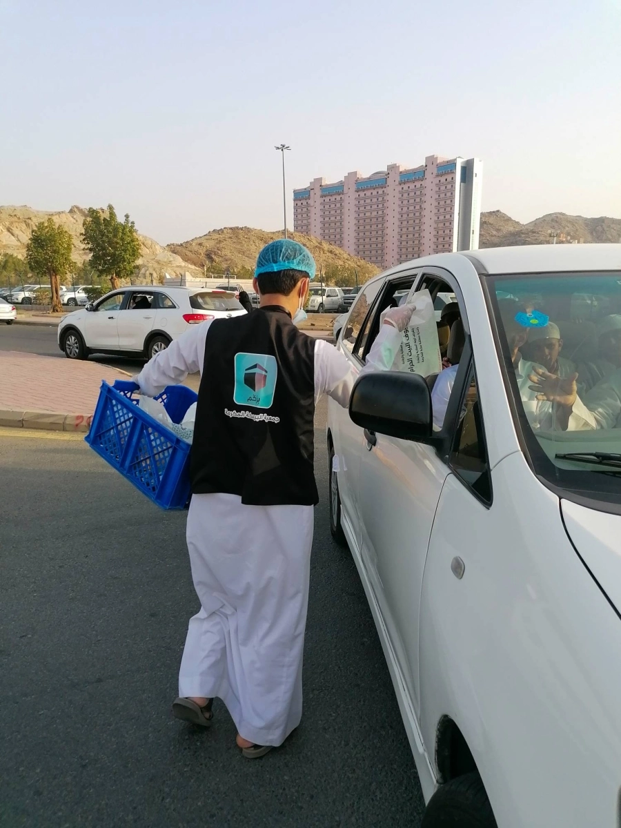 عدد من منسوبي الجمعيات الخيرية خلال توزيع وجبات إفطار صائم في شوارع العاصمة المقدسة.
