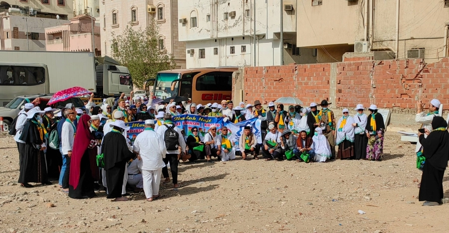 حجاج آسيويون يلتقطون صورا تذكارية بعد الفراغ من زيارتهم للأماكن السياحية والبهجة ترتسم على وجوههم

