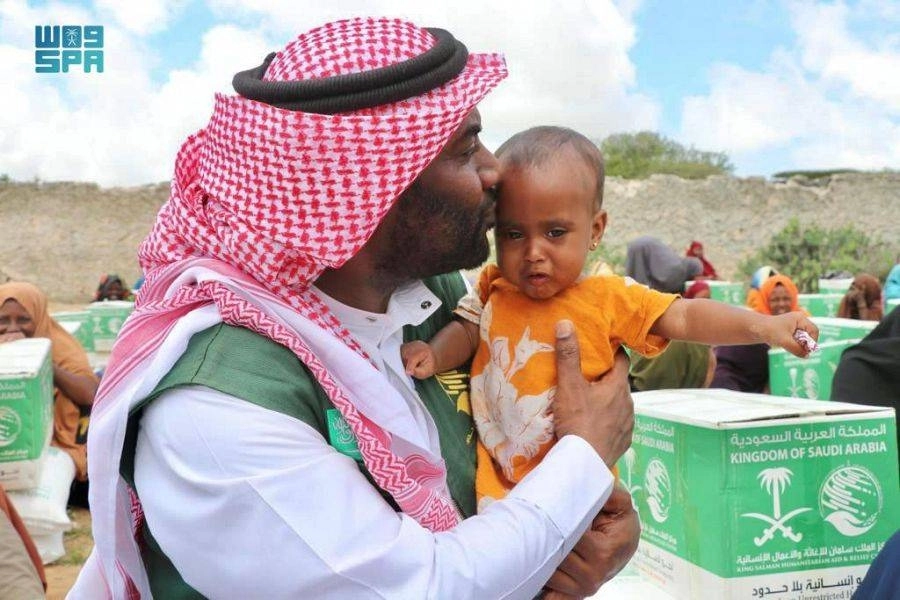 متطوع بالمركز يقبل أحد الأطفال من الأبناء المتضررين بالصومال (واس)