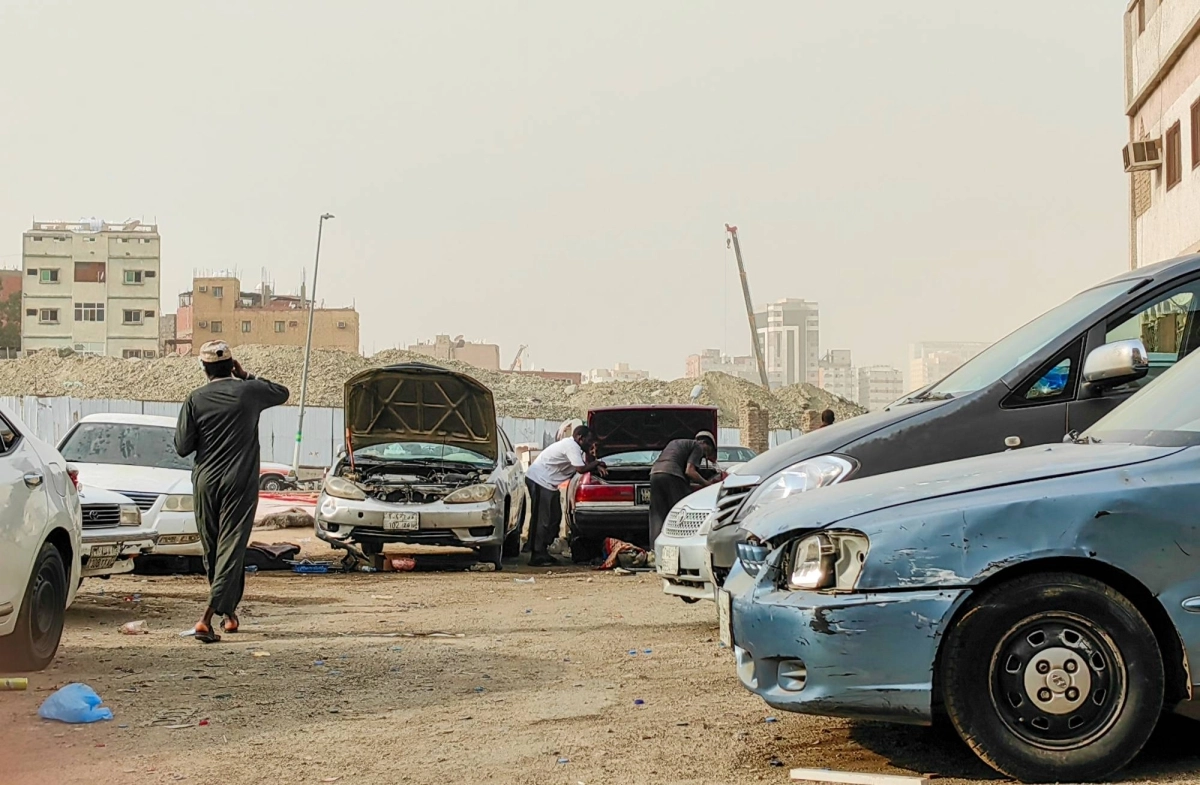 مخالفون يحولون جزءا من حوش بكر الشهير في مكة المكرمة لورشة سيارات يتم فيها التصليح والتعديلات الظاهرة دون ورقة إصلاح معتمدة. (أنس الحارثي)