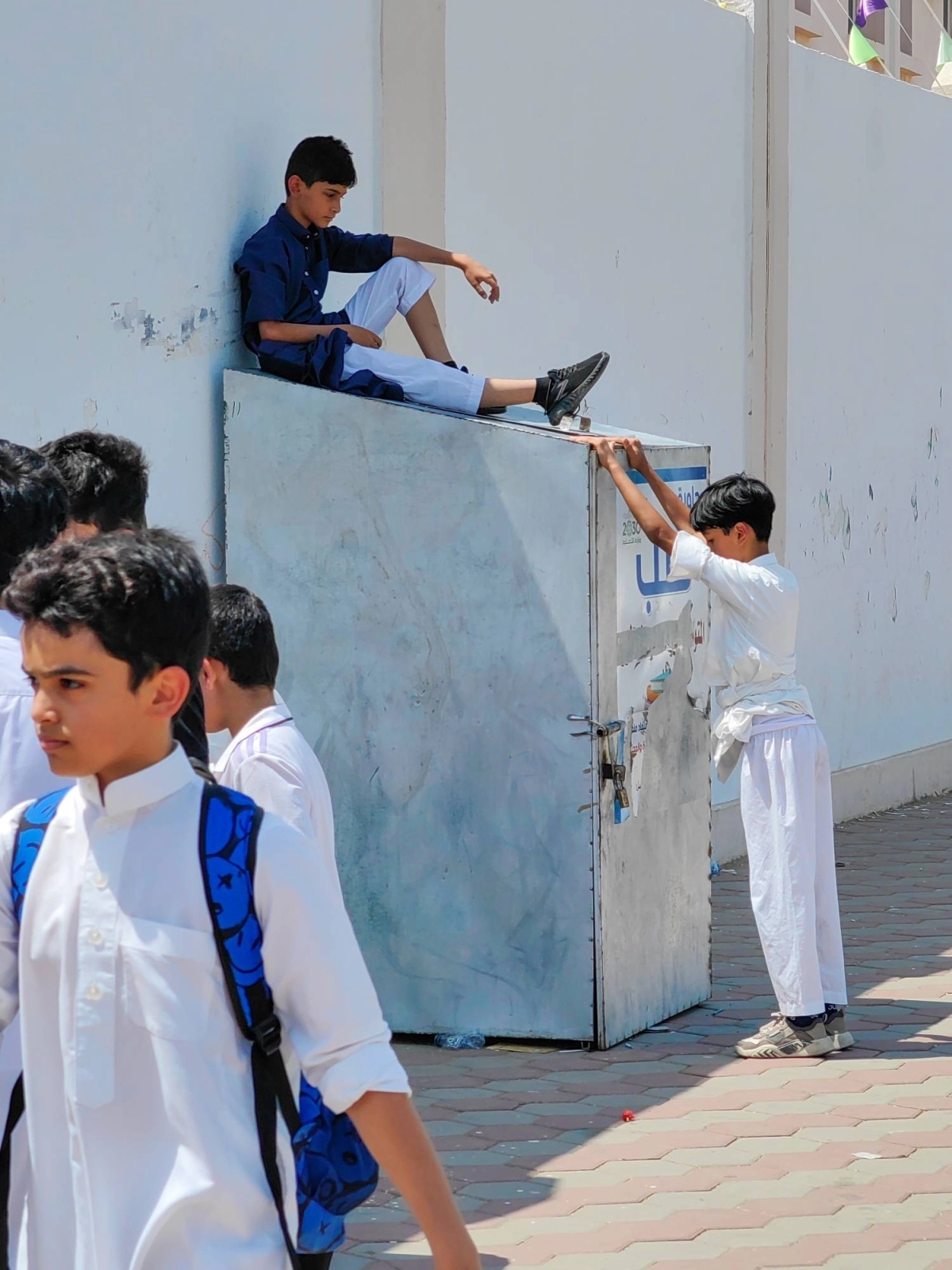 استراحة طالب بعد يوم دراسي، حيث أخذ صندوق تجميع الكتب ليعتليه في استراحة قصيرة، مستظلا من حرارة الشمس بالعاصمة المقدسة. (أنس الحارثي)
