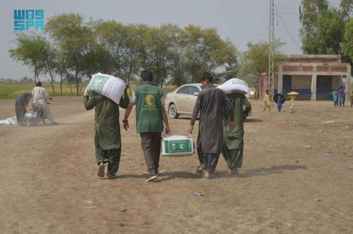 

متطوع يساعد باكستانيا في حمل السلة                                 (واس)