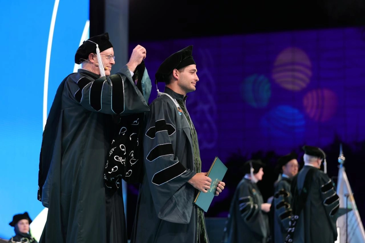 وكيل الجامعة الدكتور لاري كارين، يتوج أحد الخريجين