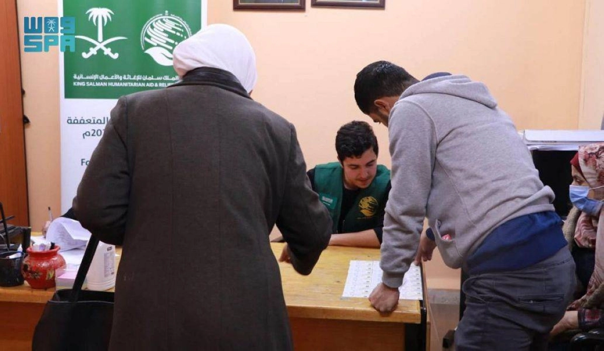 متطوع يسلم الأسر السورية قسائمها