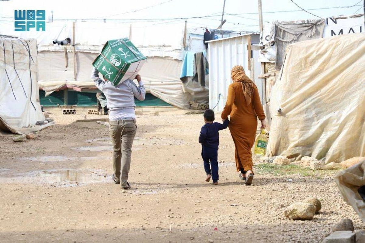 

أسرة لاجئة تعود بسلة غذائية                                        (واس)