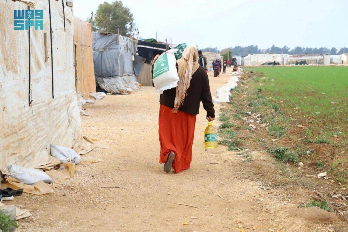 لاجئة سورية تحمل السلة الغذائية (واس)