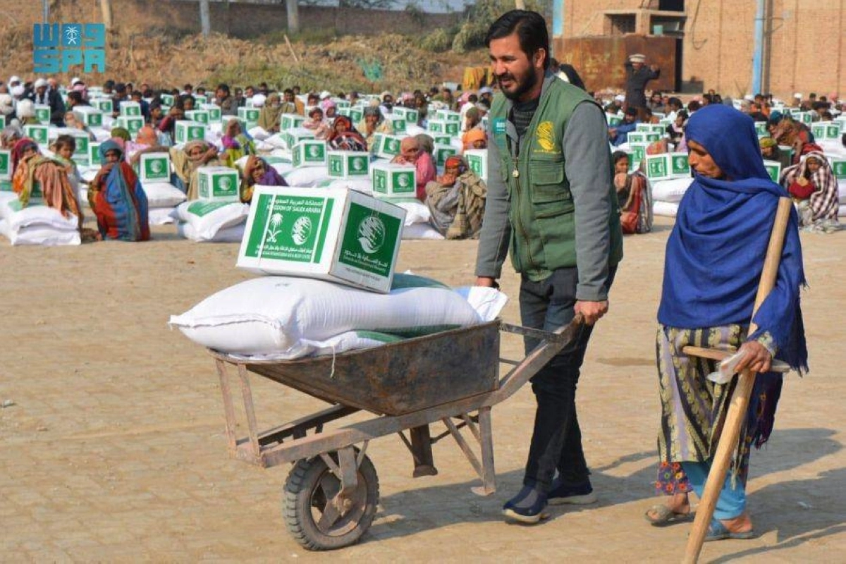 

متطوع يساعد مسنة باكستانية