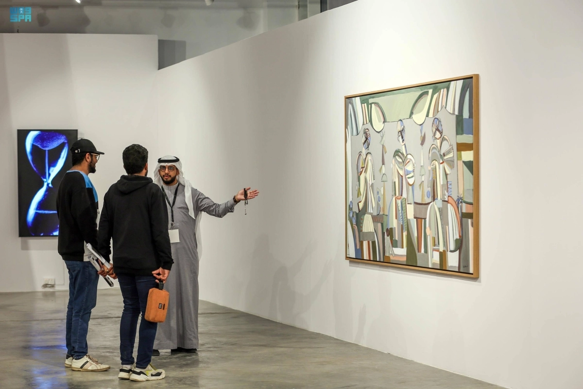  احد الفنانين يشرح احدى اللوحات المعروضة (مكة)