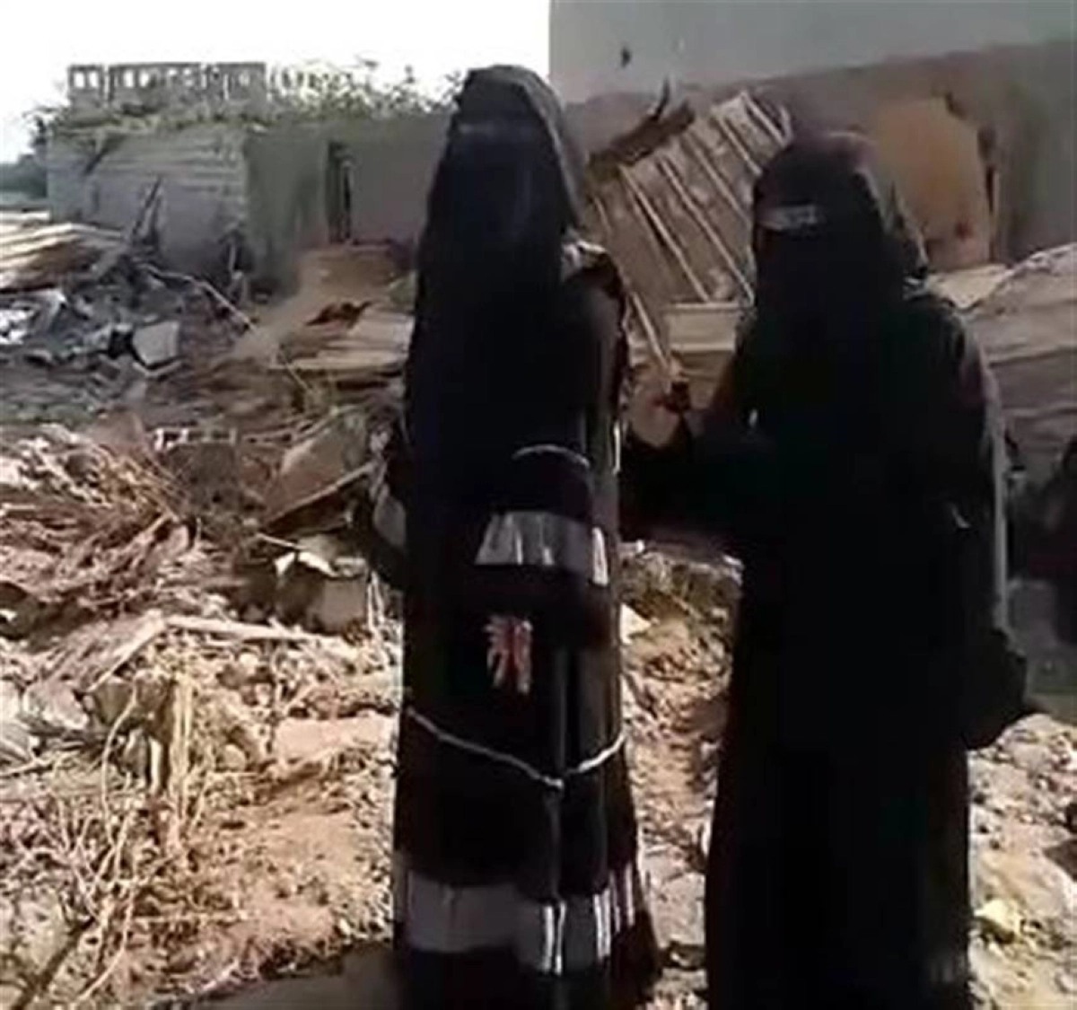 

يمنيتان أمام منزل هدمه الحوثي