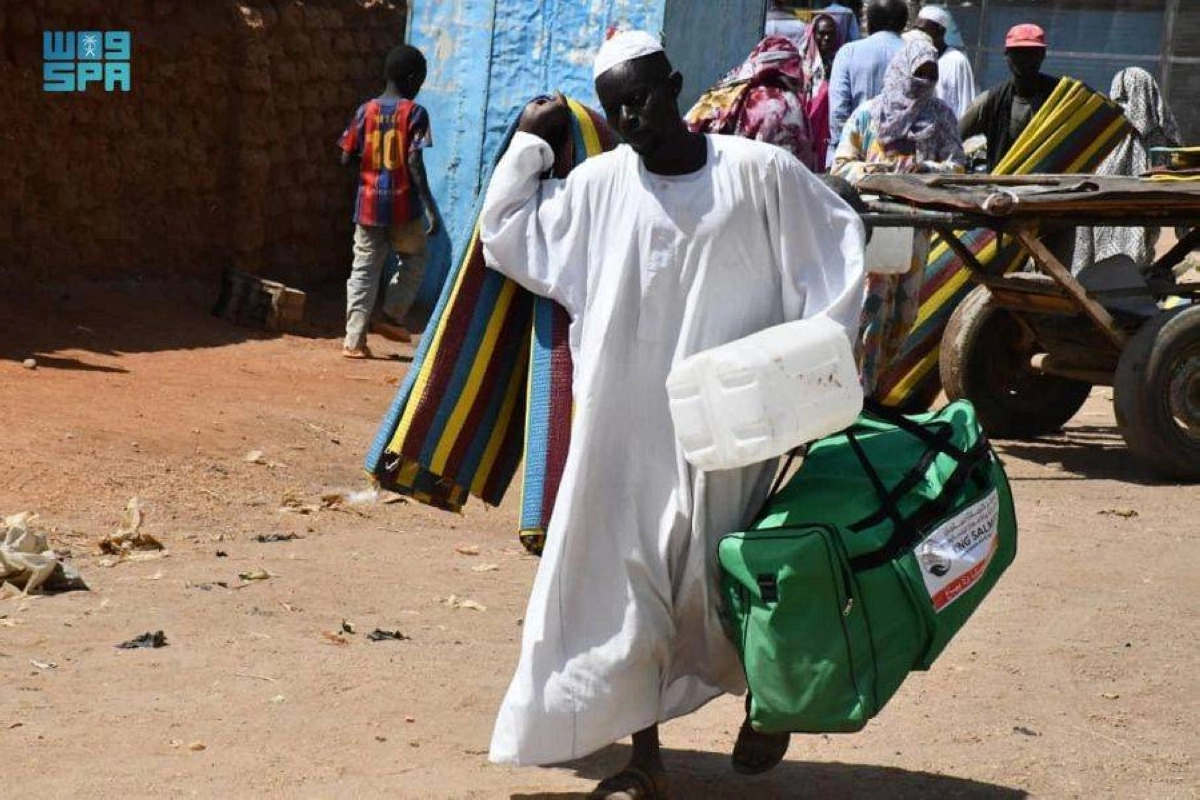 سوداني يحمل إحدى الحقائب الإيوائية السعودية (واس)
