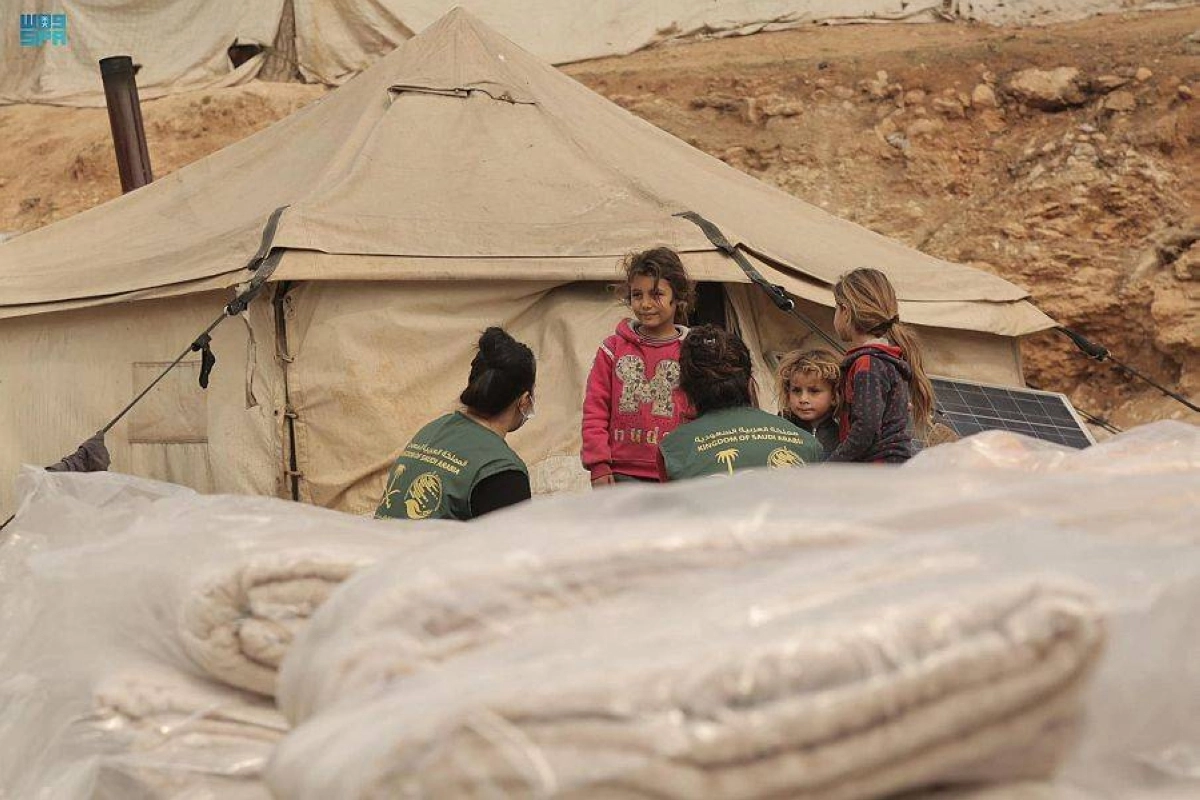 متطوعان يتحدثان لأطفال سوريين