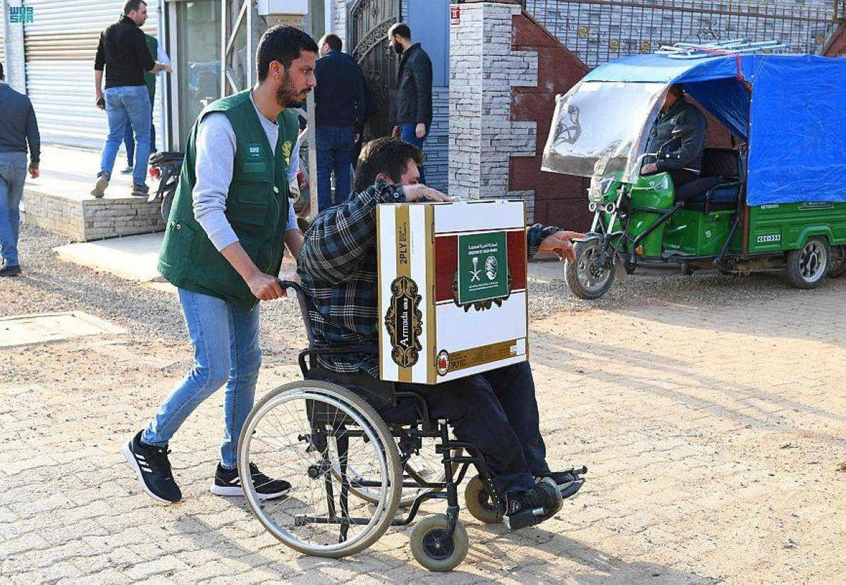 متطوع يساعد أحد المعاقين