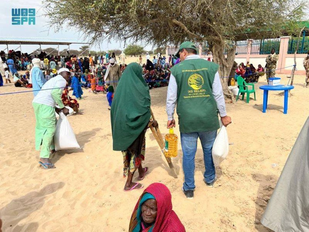 

متطوع يساعد مسنة من تشاد