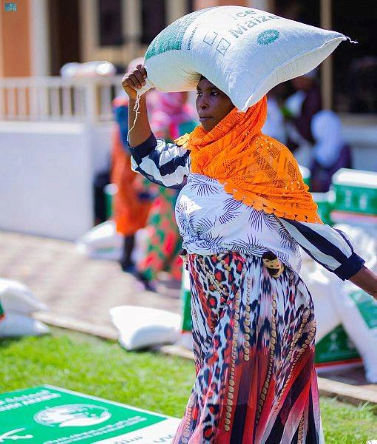 امرأة من غانا تحمل المساعدات الغذائية