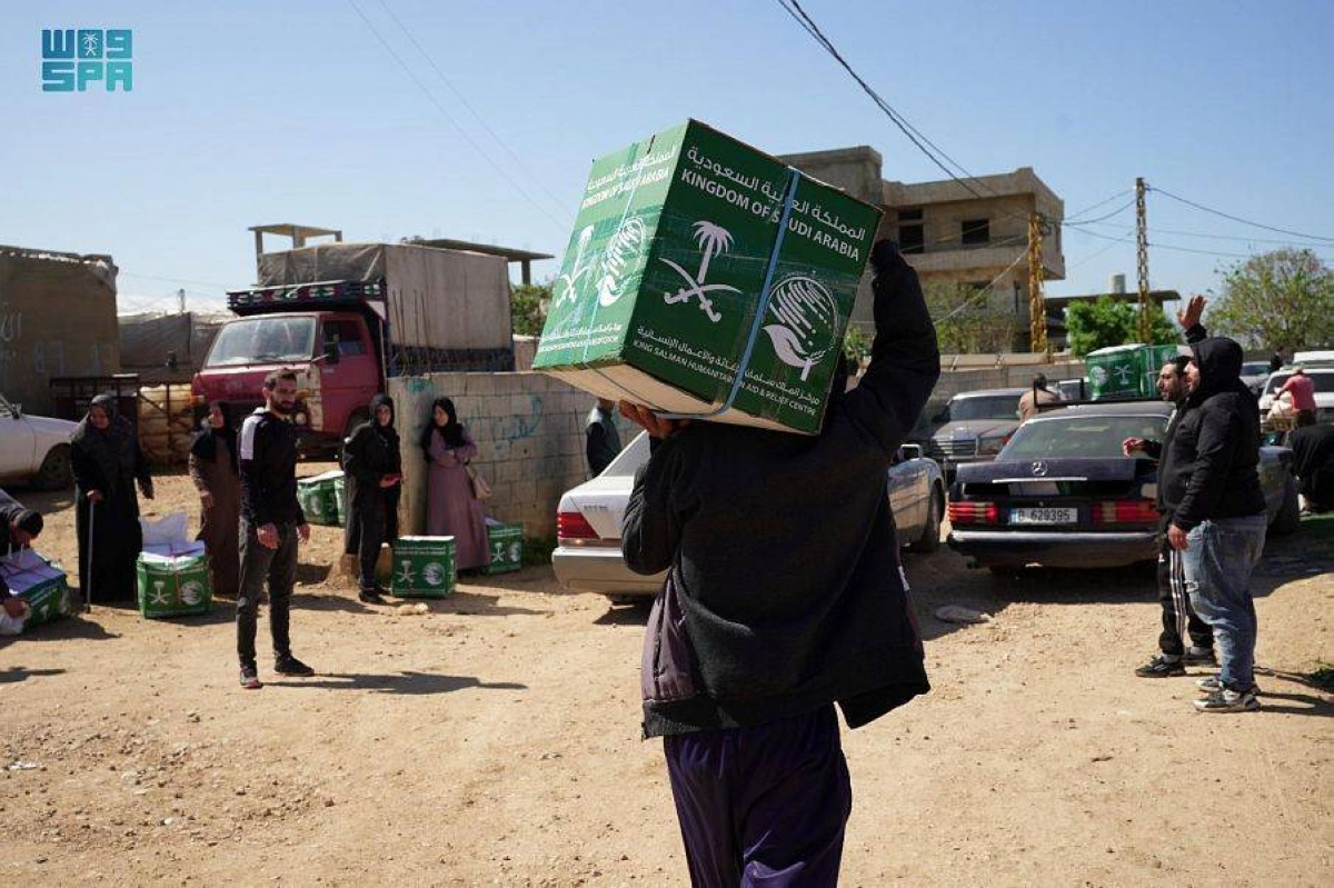 

مستفيد يحمل سلته وآخرون ينتظرون