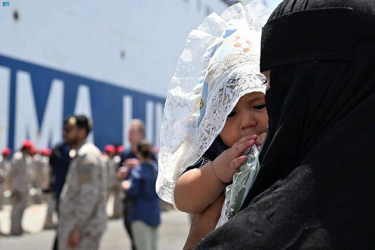 

سيدة تحمل ابنتها في ميناء جدة