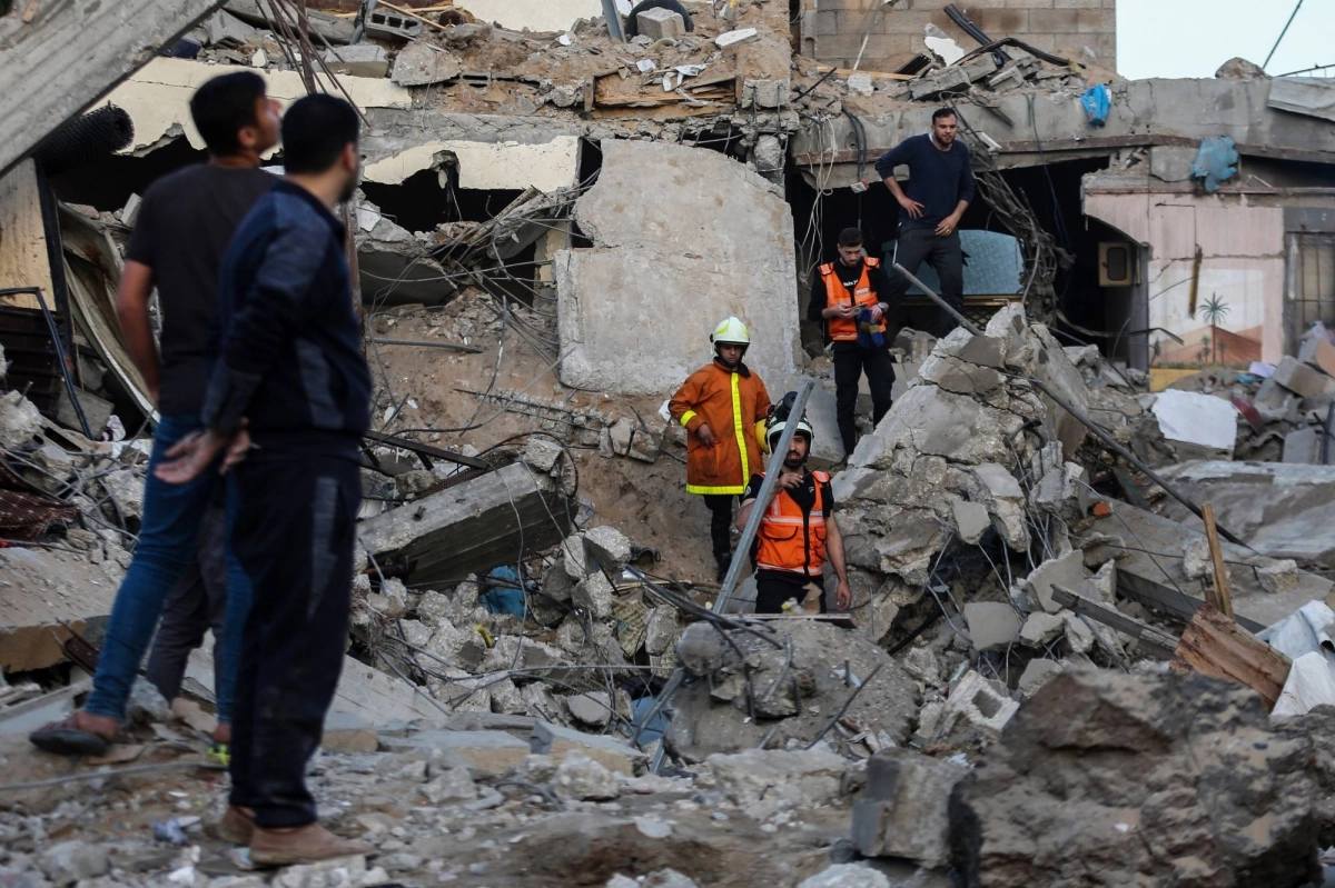  فلسطينيون وعمال طوارئ يفتشون أنقاض مبنى دمرته اسرائيل (د ب أ)