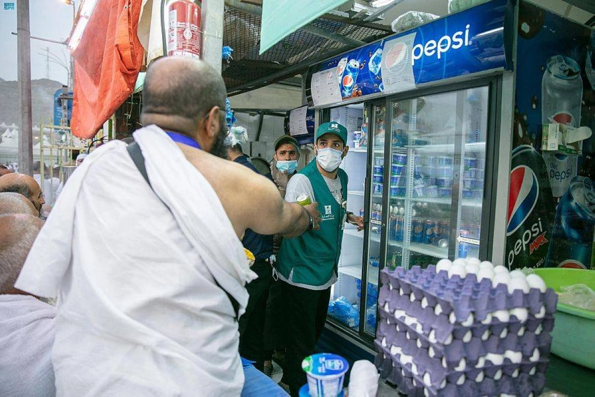 متطوع يقدم المياه لأحد الحجاج (واس)