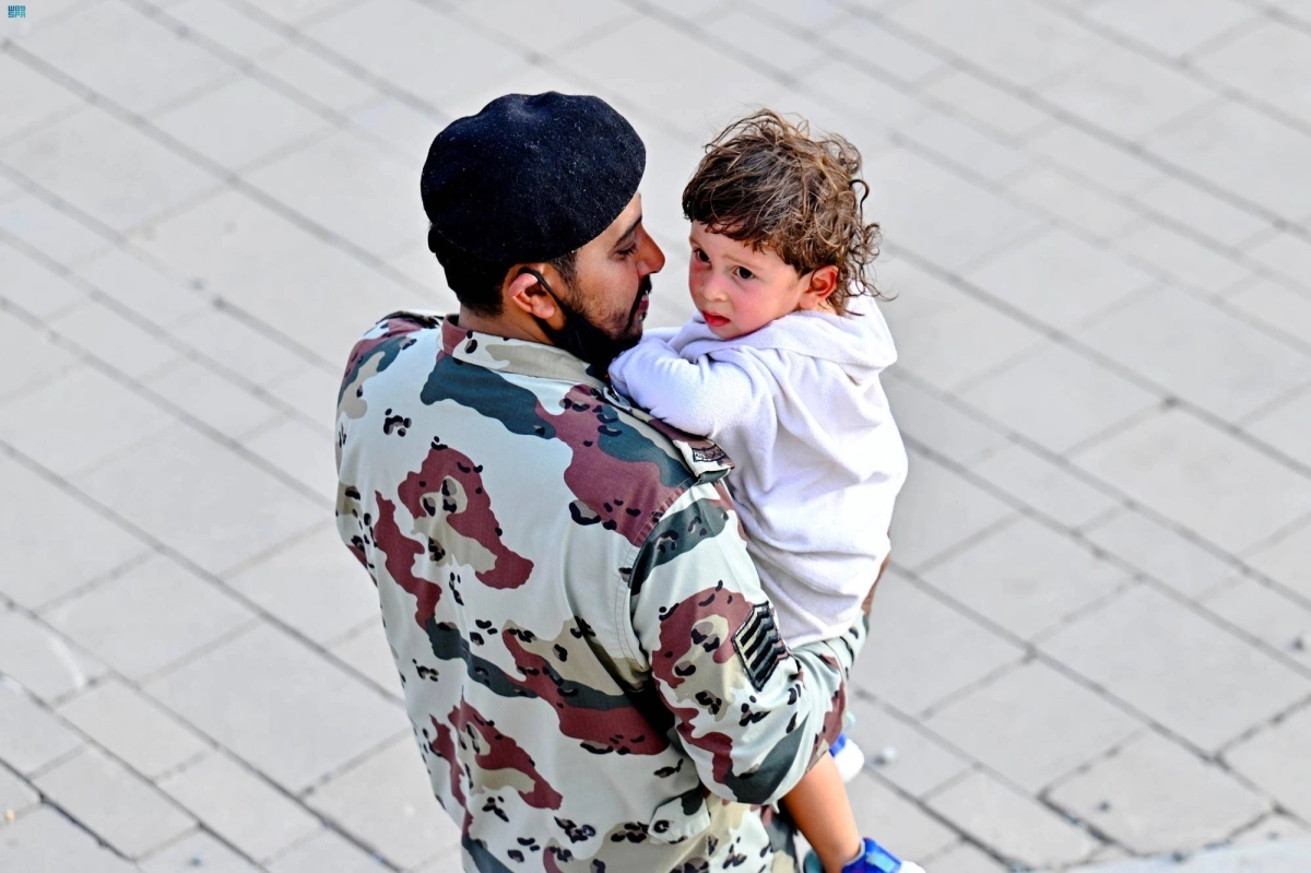 

أحد رجال الأمن يحمل طفلا