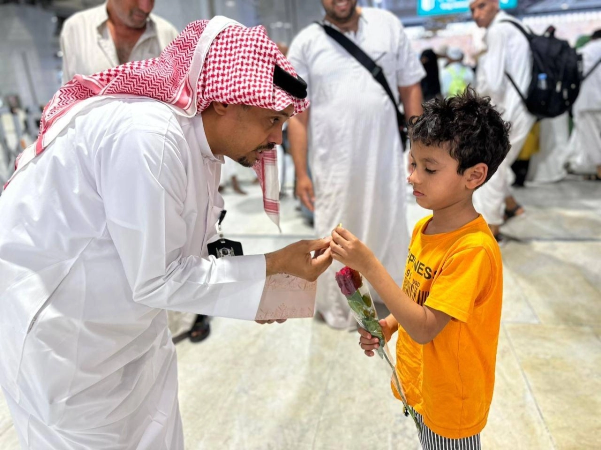 طفل يحصل على وردة من متطوع بالمسجد الحرام