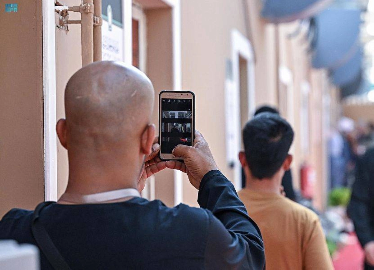 حاج يستخدم الهاتف للتواصل مع أهله (مكة)