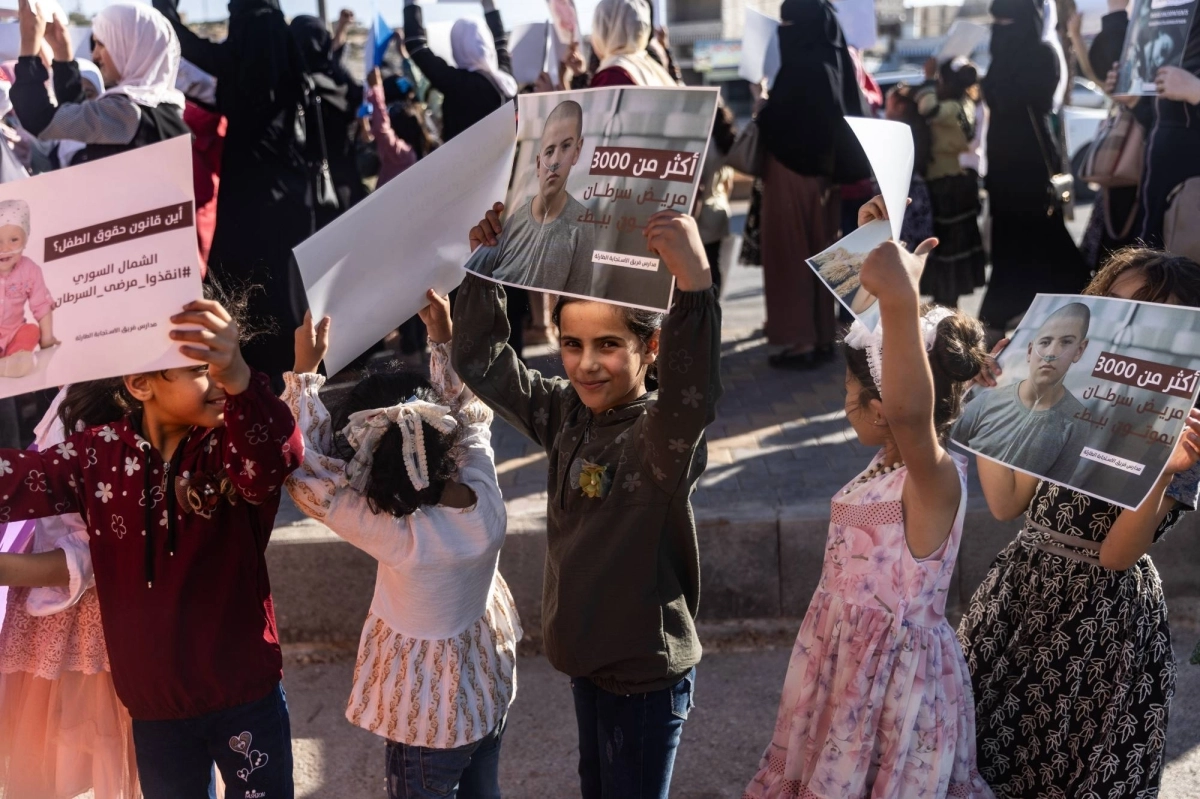 أطفال يرفعون صور ذويهم