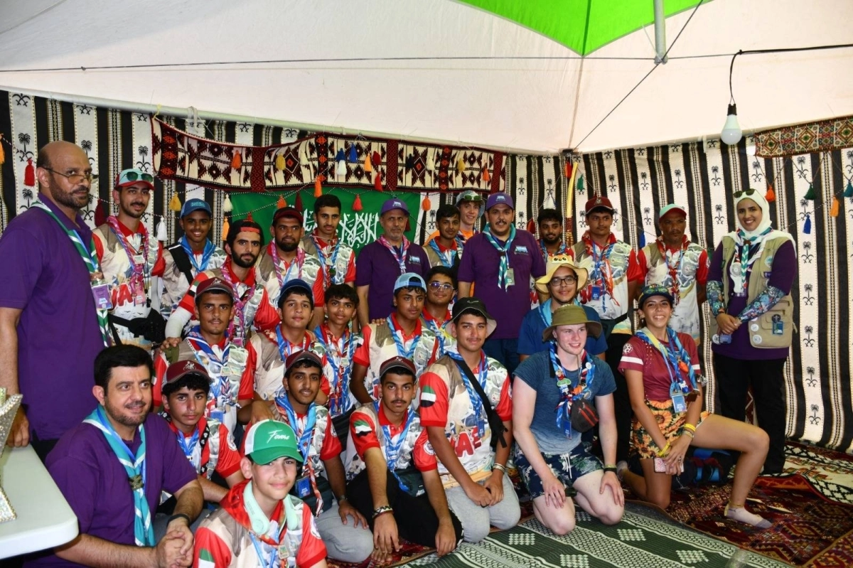 

صورة تذكارية للكشافة وخلفهم العلم السعودي