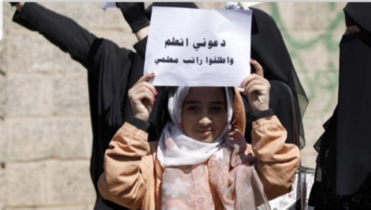 

طالبة يمنية ترفع لافتة تطالب بصرف رواتب معلميها       (مكة)