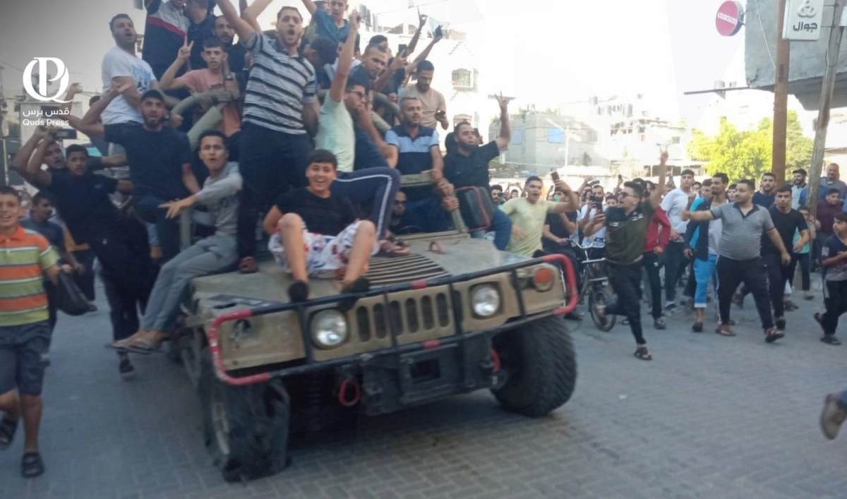 فلسطينيون يحتفلون فوق سيارة إسرائيلية استولوا عليها