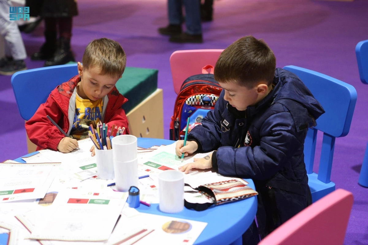 طفلان منهمكان في الرسم بالمعرض (مكة)