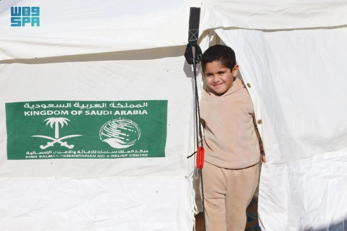 ابتسامة رضا لطفل من داخل الخيمة السعودية (واس)