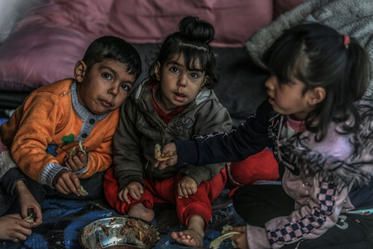 ثلاث اطفال من غزة يتجمعون حول طبق فول (د ب أ)