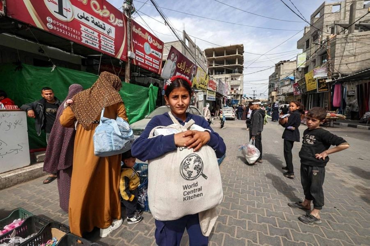 فتاة فلسطينية تحمل مساعدات غذائية في رفح (مكة)